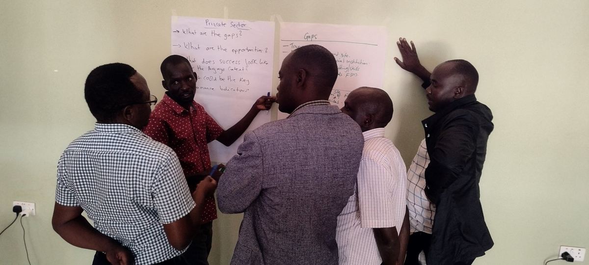 Participants discussing sanitation gaps and opportunities written on flipcharts