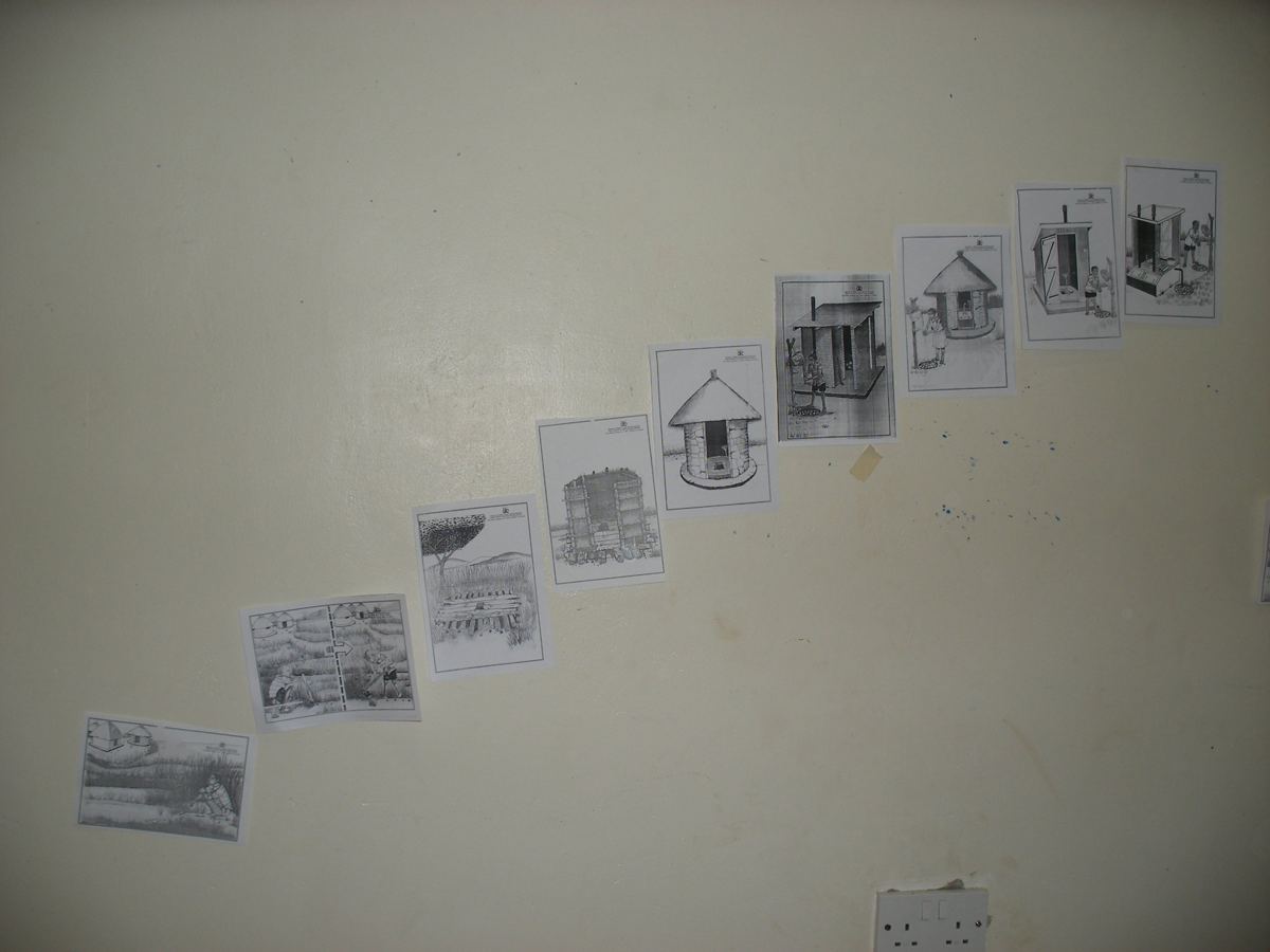 Sanitation ladder picture cards taped to a wall in a training room